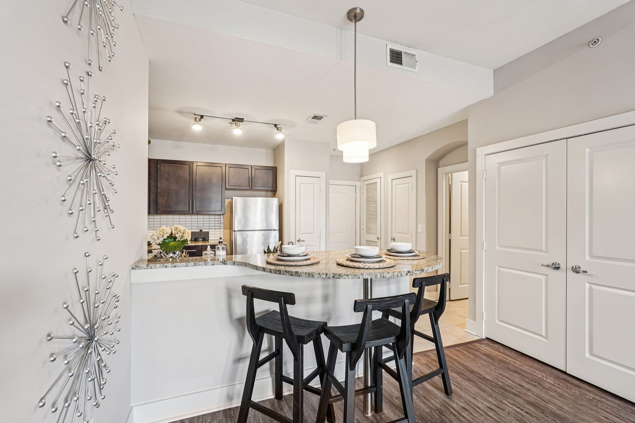 A modern kitchen with a dining table set for two.